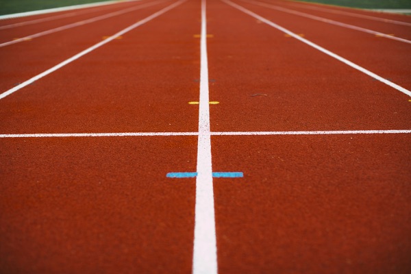 Close up of the white lane lines on a red running track
